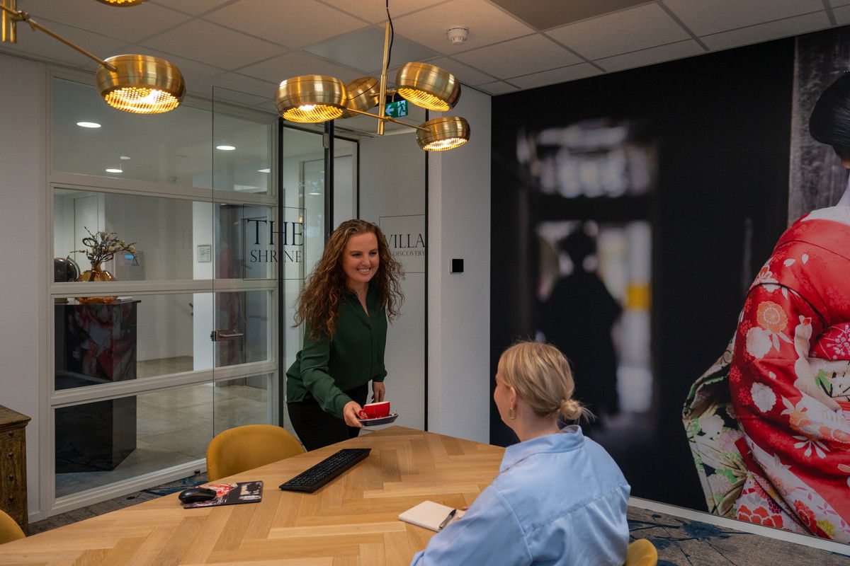 Reisspecialist Desire Schapers biedt koffie aan aan een klant